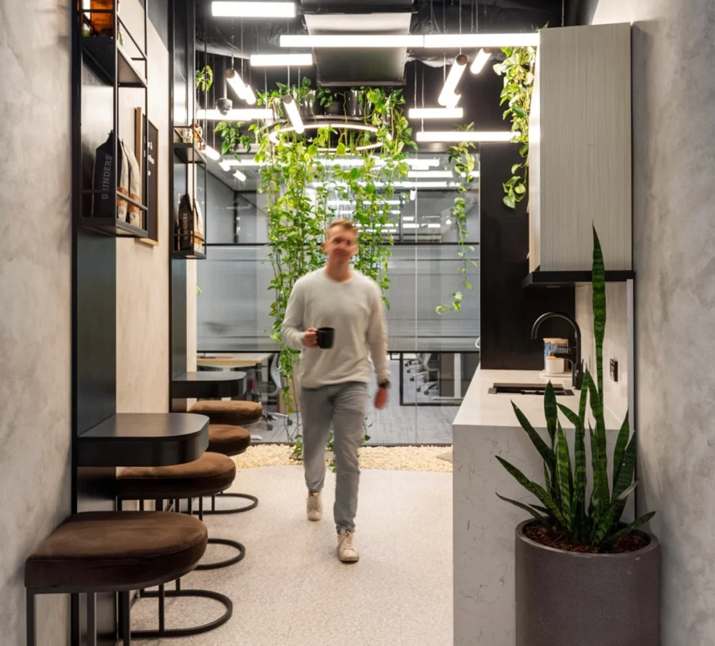 An office kitchen, one of many benefits of a serviced office, with a man walking through it